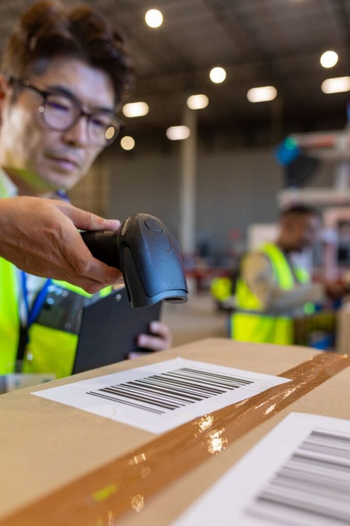 Asian warehouse worker scanning a cardboard parcel barcode during China origin shipment preparation
